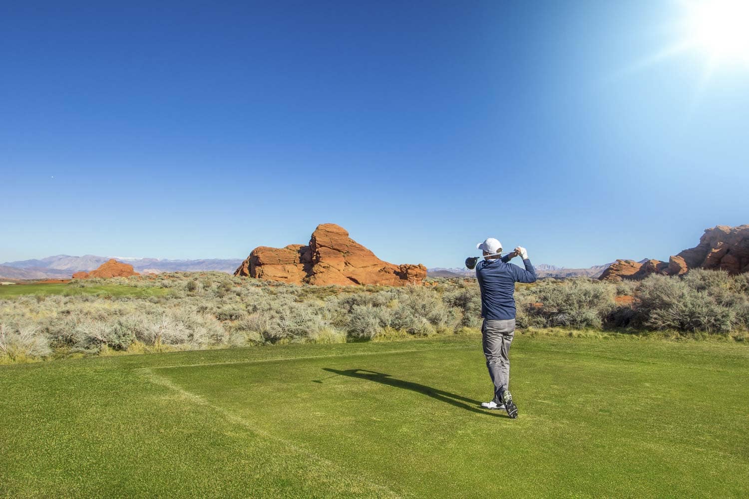 rear view of a man playing golf on a sunny day on a beautiful de