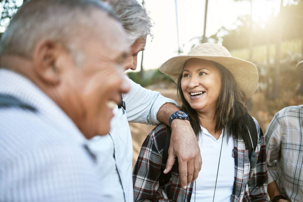 happy senior woman in nature with friends while taking an outdoor walk in spring. smiling mature woman having a conversation with a man outside. old smiling lady having fun while hiking with aged men Apache Junction AZ RV Parks